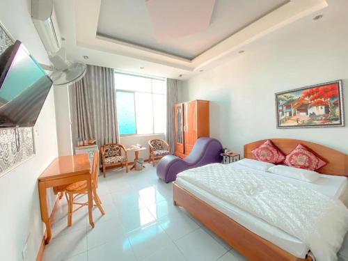 una camera con letto, tavolo e scrivania di Như Ý Hotel Lào Cai - by Bay Luxury a Pho Mới