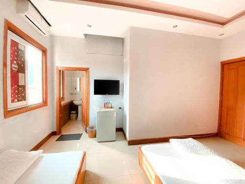 Camera bianca con 2 letti e una TV di Như Ý Hotel Lào Cai - by Bay Luxury a Pho Mới