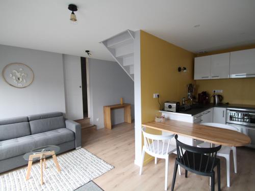 een woonkamer en een keuken met een bank en een tafel bij Apparts Watteau in Limoges