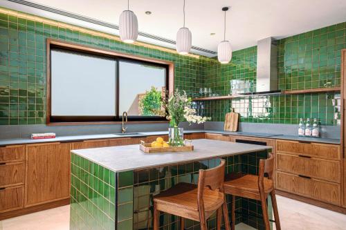 uma cozinha em azulejo verde com uma mesa e cadeiras em Meliá Desert Palm Member of Meliá Collection em Dubai