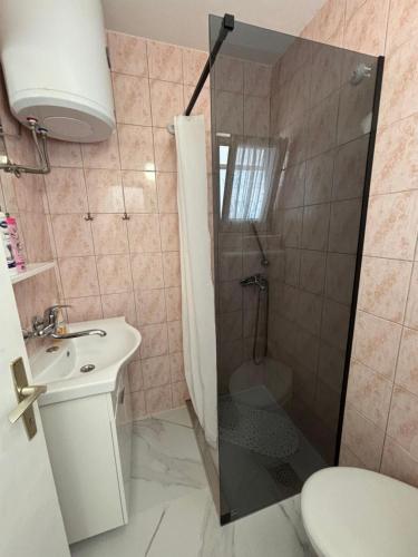 a bathroom with a shower and a toilet and a sink at Apartments Medic in Drače