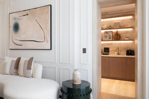 un salon avec un canapé blanc et une table dans l'établissement TheLander - Serviced Apartments in Champs Elysées, à Paris