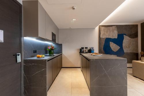 a kitchen with gray cabinets and a counter top at Noom Hotel Abidjan Plateau in Abidjan
