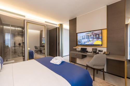 a hotel room with a bed and a tv at Noom Hotel Abidjan Plateau in Abidjan