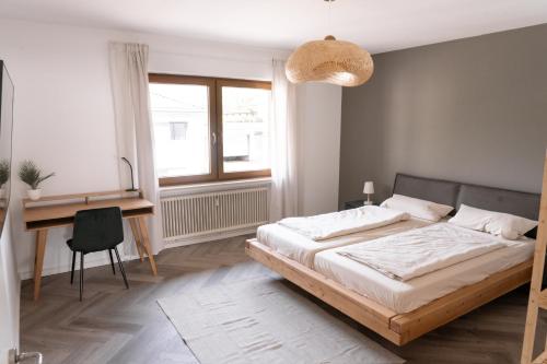 ein Schlafzimmer mit einem Bett und einem Schreibtisch und einem Schreibtisch in der Unterkunft TRIMOSA - Apartments & Homes in Trierweiler