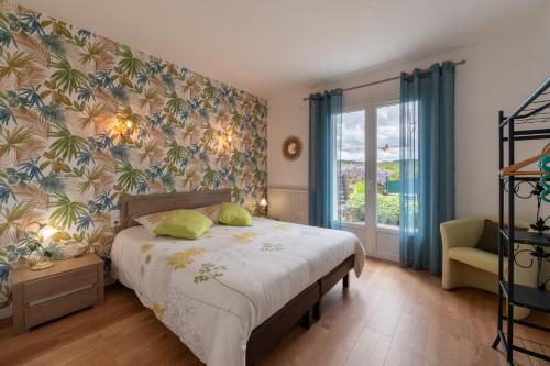 a bedroom with a bed and a window at Jardins de la Cantine- Terre et mer in Locminé