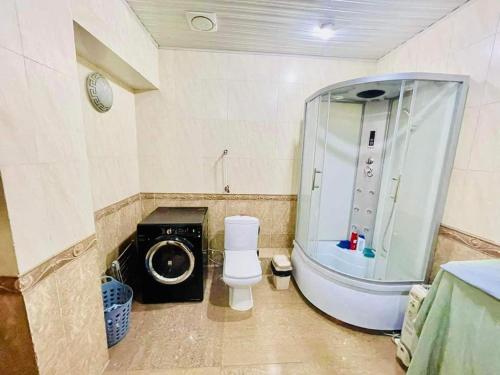 a bathroom with a toilet and a washing machine at Five seasons guest house in Ulaanbaatar