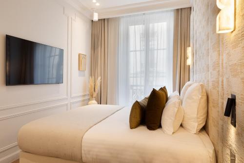 - une chambre avec un lit doté d'oreillers et une télévision dans l'établissement TheLander - Serviced Apartments in Champs Elysées, à Paris