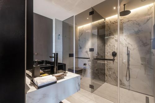 a bathroom with a shower with a glass door at Noom Hotel Abidjan Plateau in Abidjan