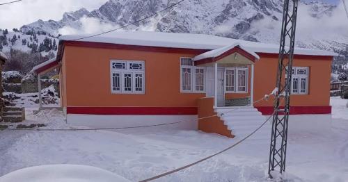 ein kleines Haus im Schnee mit einem Berg in der Unterkunft Summer Heaven Guesthouse in Tandal