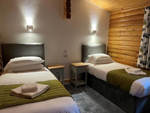 Habitación con 2 camas con sombreros. en Pantglas Hall Holiday Lodges and Leisure Club, en Carmarthen