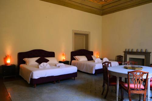 um quarto com duas camas e uma mesa e cadeiras em Mamo Florence - Tintori Luxury Palace em Florença