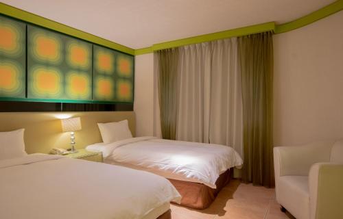 a hotel room with two beds and a chair at Kenting Southern Dream Resort in Kenting