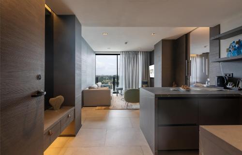 a kitchen with a counter and a living room at Noom Hotel Abidjan Plateau in Abidjan