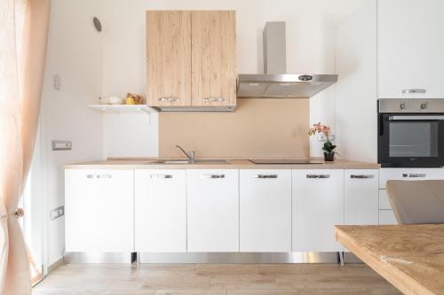 a kitchen with white cabinets and a sink at Casa Vacanze Alba Mar in SantʼAntìoco