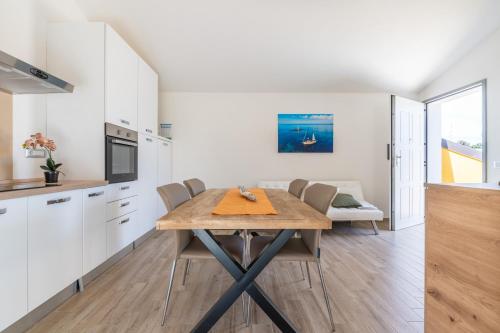 a kitchen and dining room with a table and chairs at Casa Vacanze Alba Mar in SantʼAntìoco