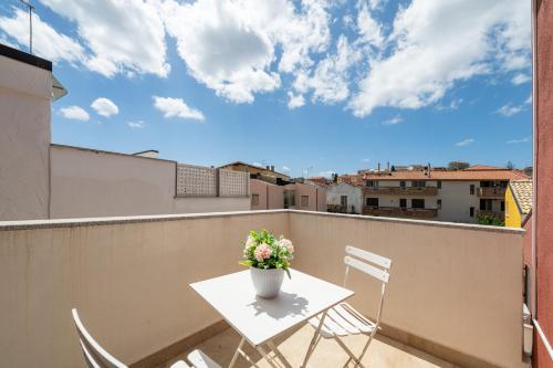 a table and chairs on a balcony with a vase of flowers at Casa Vacanze Alba Mar in SantʼAntìoco