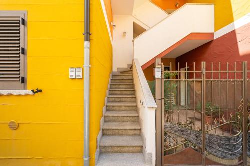 a stairway leading up to a yellow building at Casa Vacanze Alba Mar in SantʼAntìoco