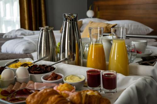 a breakfast tray with breakfast foods and drinks on a bed at Hotell Boras, BW Signature Collection in Borås
