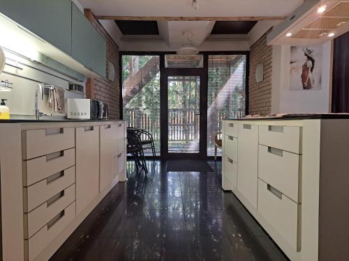 a kitchen with white cabinets and a black floor at Champêtre Park View Apartments in Riga