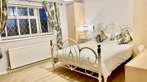 a bedroom with a white bed and a window at Serenity in Peterborough