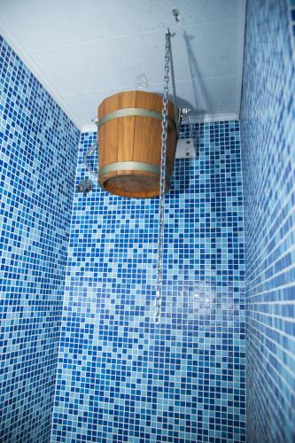 a blue tiled bathroom with a barrel on the wall at Family Hotel Emaly 2 in Sapareva Banya