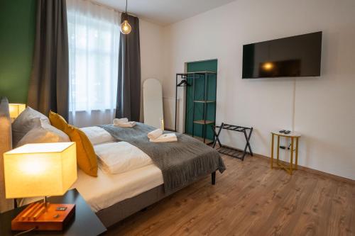 a bedroom with a bed and a tv on the wall at T21 - Boardinghouse im Citycenter mit Parkplatz in Chemnitz
