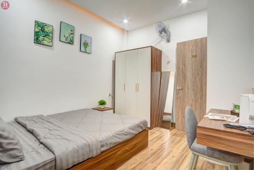 - une chambre avec un lit et un bureau dans l'établissement Tân Hoà Homestay, à Đà Nẵng