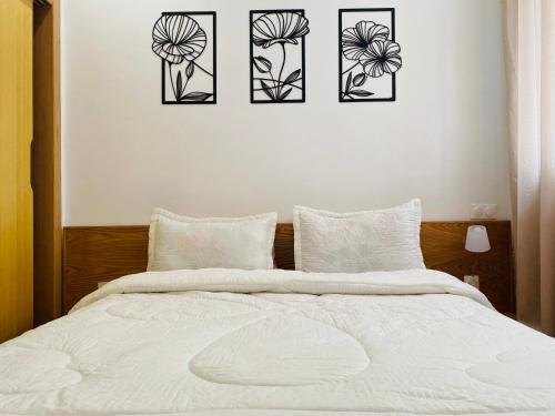 a bedroom with four pictures of flowers on the wall at Élégance en 40 mètres Nouaceur in Nouaceur