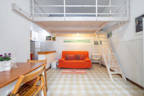 een woonkamer met een oranje bank en een ladder bij Monolocale Ginetto in Calasetta