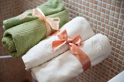 een stapel handdoeken met bogen erop in de badkamer bij Monolocale Ginetto in Calasetta