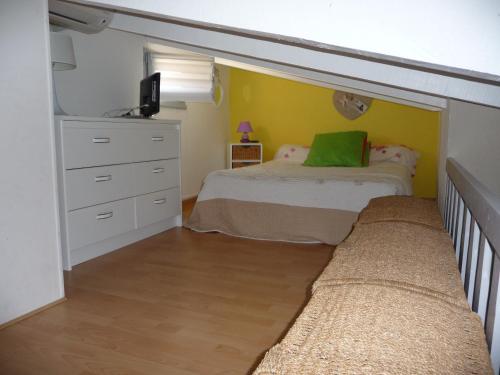 une chambre avec un lit et une commode dans l'établissement EUREKA LOCATIONS, au Cap d'Agde