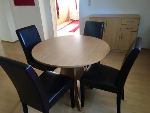 a wooden table with four black chairs around it at Gösser BACHGASSLHOF -- Bed and Breakfast -- Apartments in Leoben