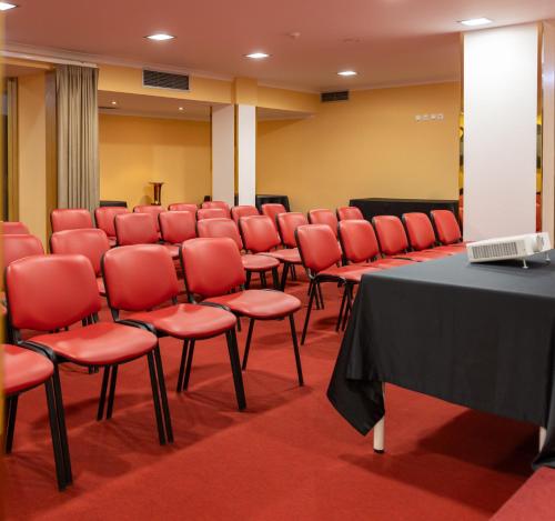 a conference room with red chairs and a table at Hotel Regina in Fátima