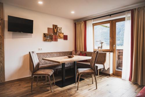 a dining room with a table and chairs and a window at Gästehaus Einödberg in Mittersill