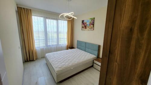 een slaapkamer met een bed en een raam bij EL-EM APARTMENTS-В-301 in Vasil Levski