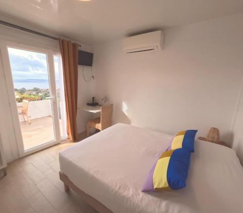 a bedroom with a bed with a view of a balcony at Azur Hotel in Le Lavandou