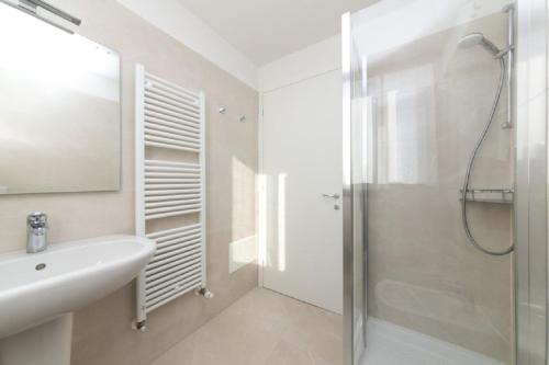a white bathroom with a shower and a sink at Pellestrina Domus - Italianflat in Venice