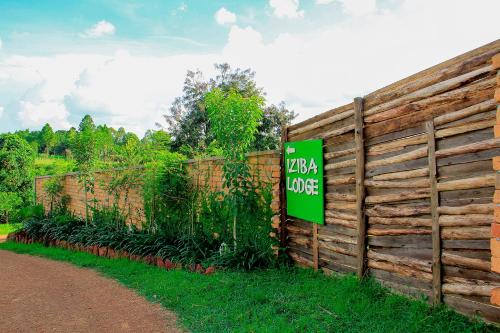 a fence with a sign that reads luana lodge at Iziba Lodge - Hoima in Hoima