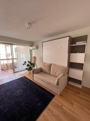 un salon avec un canapé et une étagère dans l'établissement Beautiful studio - Terrace, à Nice