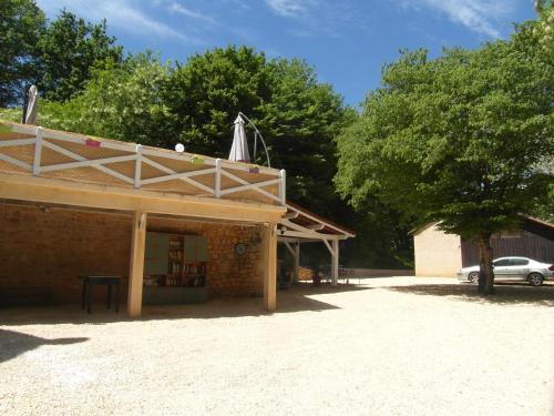 un bâtiment avec une table et un parasol sur le toit dans l'établissement Gîtes du Bois de Bontemps, à Sarlat-la-Canéda
