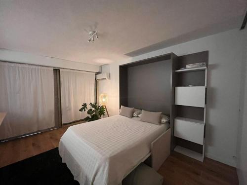 une chambre avec un lit et une étagère dans l'établissement Beautiful studio - Terrace, à Nice