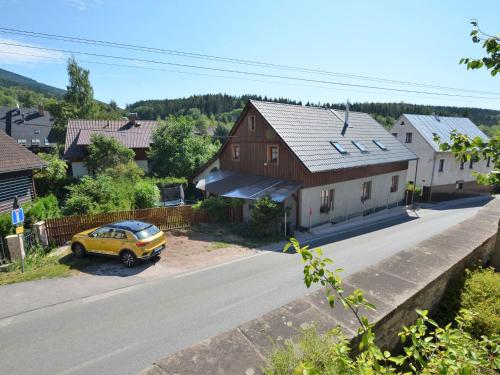 un coche amarillo estacionado frente a una casa en Modern Holiday Home in Cern Dul with Private Garden, en Černý Důl