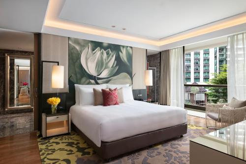 a bedroom with a large bed and a large window at Siam Kempinski Hotel Bangkok in Bangkok