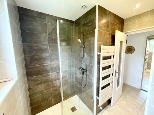 une salle de bain avec une douche avec une porte vitrée dans l'établissement Appartement Le Cosy - Rénové - 3 Chambres, à Oyonnax