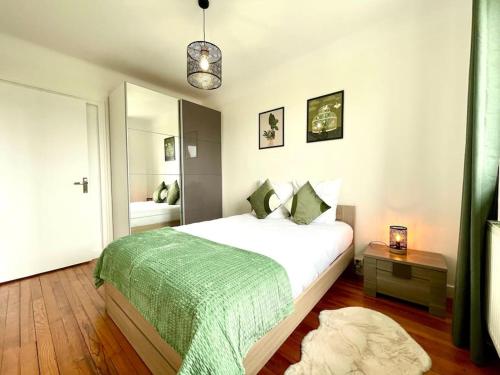 une chambre avec un grand lit avec une couverture verte dans l'établissement Appartement Le Cosy - Rénové - 3 Chambres, à Oyonnax