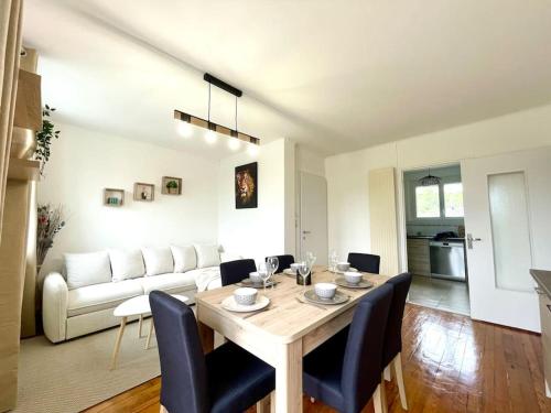 un salon avec une table et un canapé dans l'établissement Appartement Le Cosy - Rénové - 3 Chambres, à Oyonnax