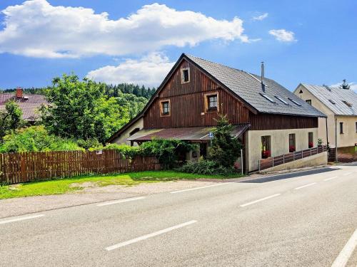 una gran casa de madera al lado de una carretera en Modern Holiday Home in Cern Dul with Private Garden, en Černý Důl