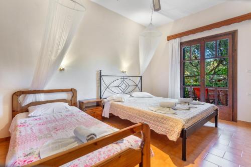 a bedroom with two beds and a window at Castellos Bellos Studio 3 in Marathias