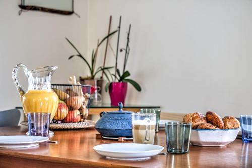 a wooden table with plates and glasses of juice and bread at Large house with garden in Bougival - Welkeys in Bougival